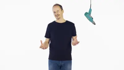 Portrait of Dietrich Kuhlgatz, Head of Historical Communications at Bosch, against a white background and a historical drill driver hanging from the ceiling next to him.